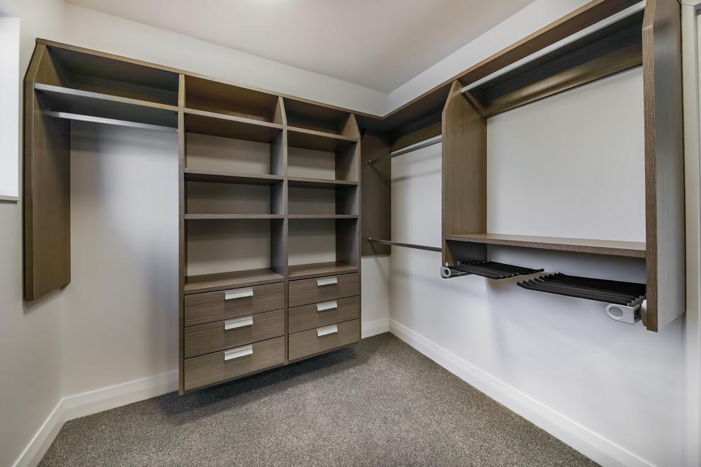 Inspiration for a medium sized coastal gender neutral walk-in wardrobe in Wellington with open cabinets, dark wood cabinets, carpet and grey floors.