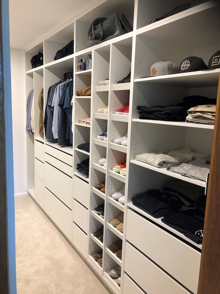 Diseño de armario vestidor actual de tamaño medio con armarios con paneles lisos, puertas de armario blancas, moqueta y suelo blanco