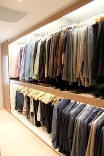 Imagen de armario vestidor de hombre contemporáneo de tamaño medio con puertas de armario de madera oscura, moqueta y armarios abiertos