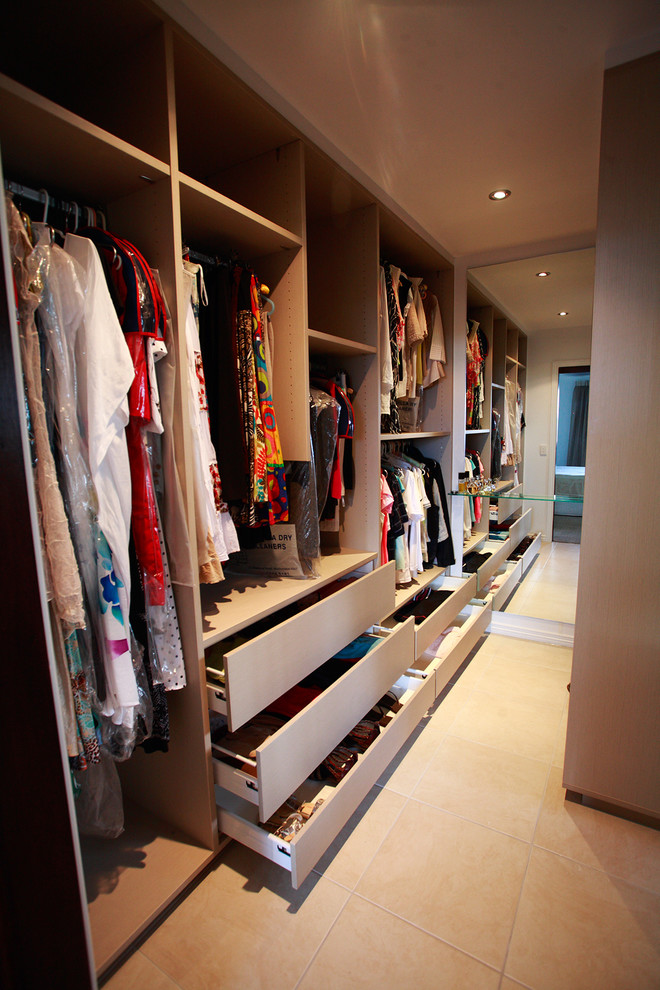 Diseño de armario vestidor unisex tradicional grande con armarios abiertos, suelo de travertino y suelo beige