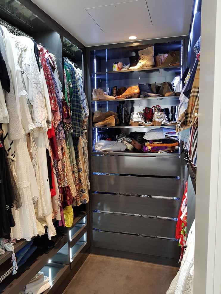 Diseño de armario vestidor contemporáneo pequeño con armarios con paneles lisos, puertas de armario de madera en tonos medios, moqueta y suelo marrón