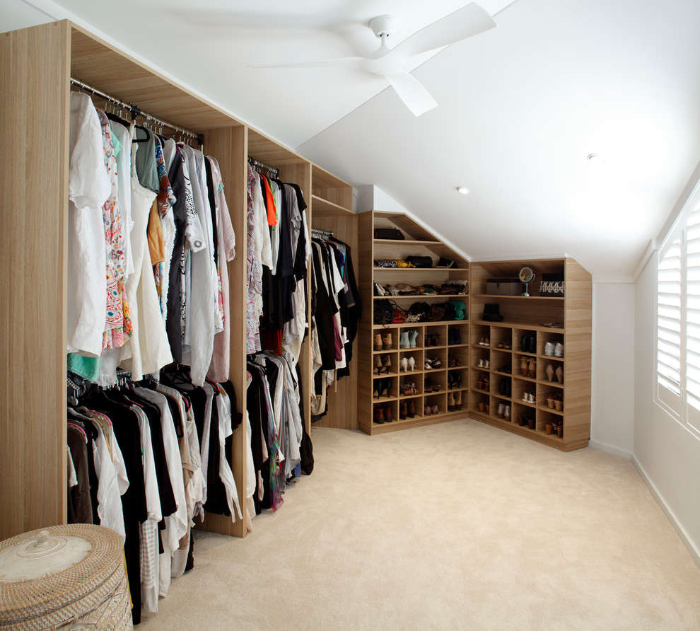 На фото: гардеробная комната унисекс в современном стиле с открытыми фасадами, светлыми деревянными фасадами, ковровым покрытием и бежевым полом