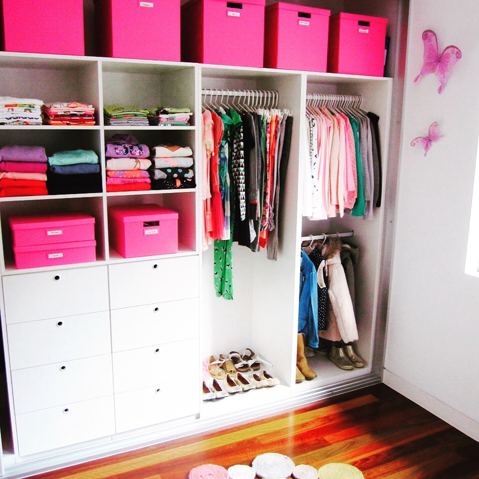 Diseño de armario de mujer minimalista de tamaño medio con armarios con paneles empotrados, puertas de armario blancas, suelo de madera en tonos medios y suelo marrón