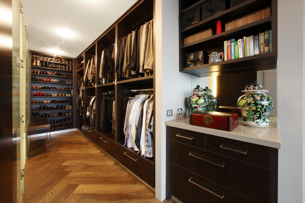 Modelo de armario vestidor unisex minimalista con puertas de armario de madera en tonos medios y suelo de madera en tonos medios