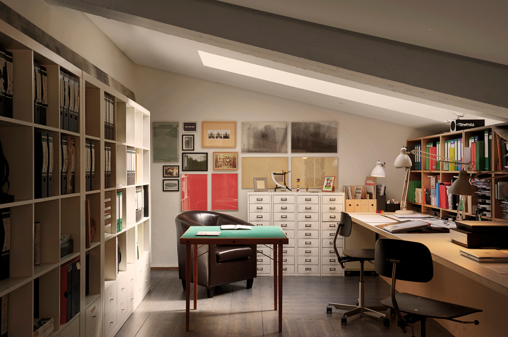 Kleines Modernes Arbeitszimmer mit Arbeitsplatz, dunklem Holzboden, Einbau-Schreibtisch und weißer Wandfarbe in Mailand