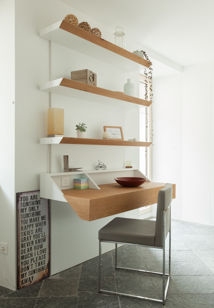 Foto di uno studio minimal di medie dimensioni con libreria, pareti bianche, pavimento in marmo, scrivania autoportante e pavimento grigio