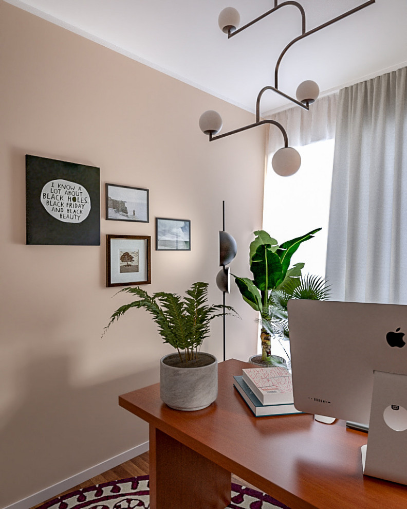 Kleines Modernes Arbeitszimmer mit Arbeitsplatz, rosa Wandfarbe, dunklem Holzboden und freistehendem Schreibtisch