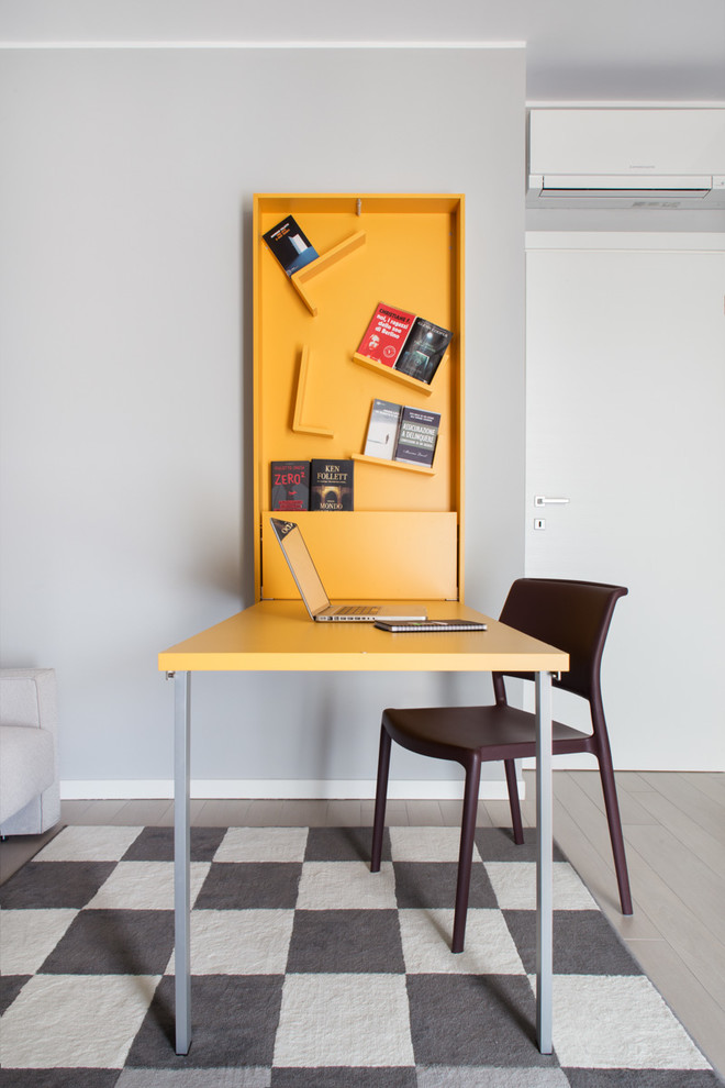 Ejemplo de estudio contemporáneo pequeño con paredes grises, suelo de madera clara y escritorio independiente