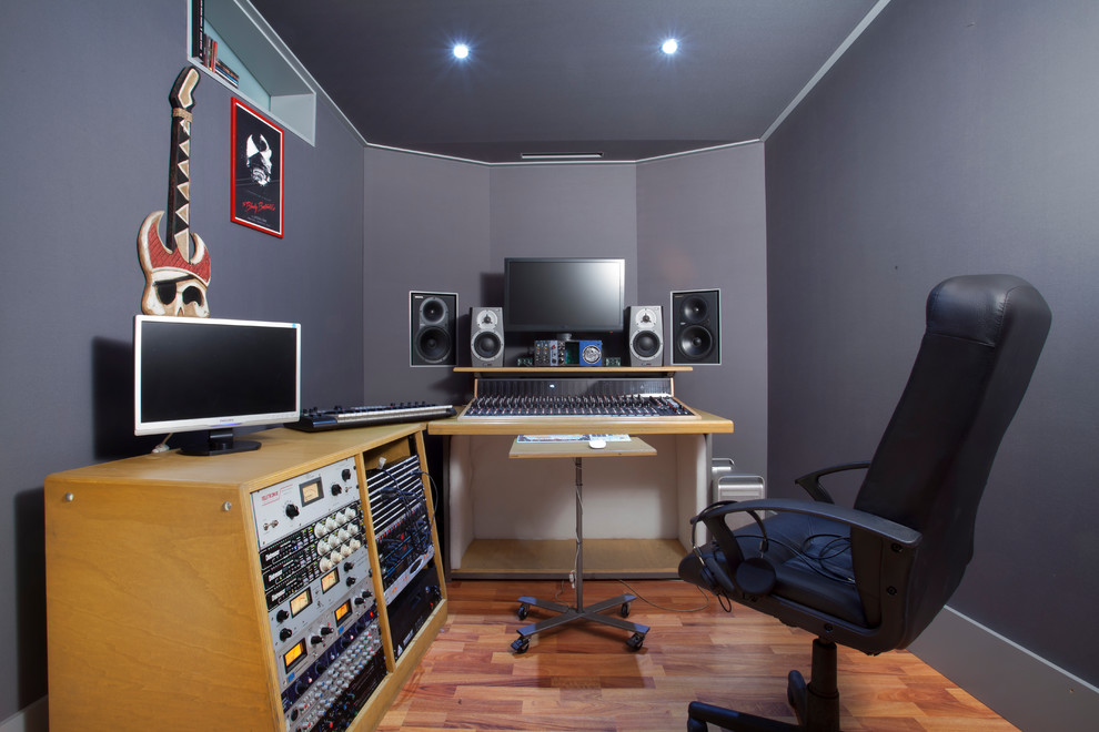 Cette image montre un bureau design de type studio avec un mur gris, un sol en bois brun, un bureau indépendant et un sol marron.