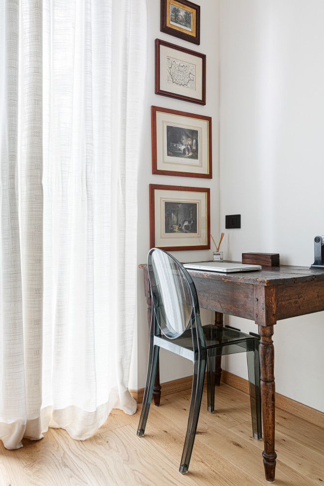 Diseño de despacho nórdico pequeño con paredes blancas, suelo de madera clara, escritorio independiente, bandeja y suelo beige