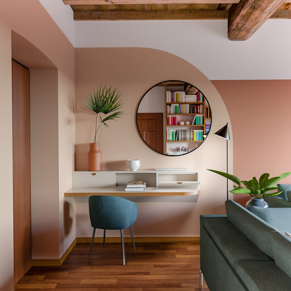 Ejemplo de despacho actual de tamaño medio con biblioteca, paredes multicolor, suelo de madera en tonos medios, escritorio empotrado y suelo marrón
