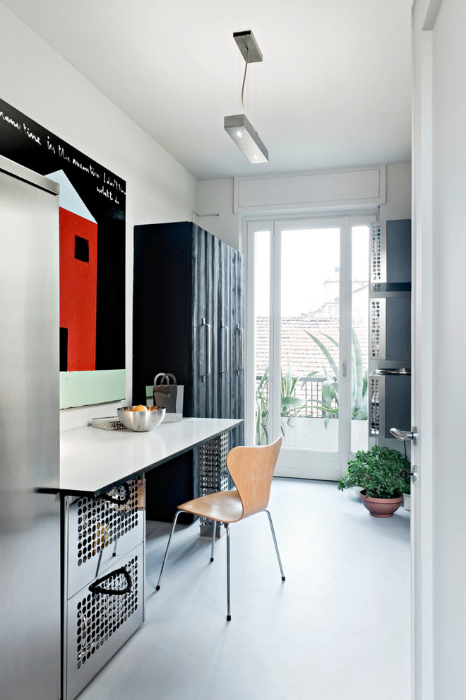 Immagine di un piccolo ufficio design con pareti bianche, pavimento in cemento, nessun camino, pavimento grigio e scrivania incassata