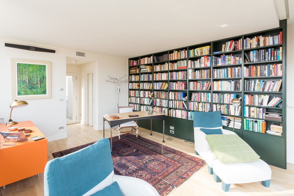 Foto di uno studio minimal con libreria, pareti bianche, parquet chiaro, scrivania autoportante e pavimento beige