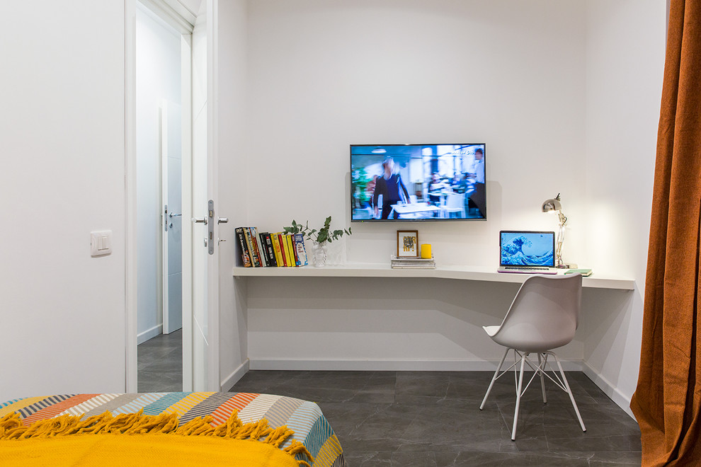 Modern inredning av ett litet arbetsrum, med vita väggar, ett inbyggt skrivbord och grått golv