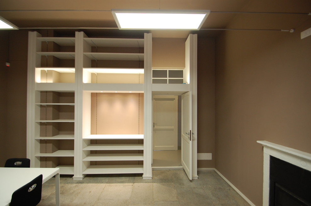 Idéer för att renovera ett stort funkis arbetsrum, med ett bibliotek, bruna väggar, kalkstensgolv, en standard öppen spis, en spiselkrans i betong, ett fristående skrivbord och grått golv