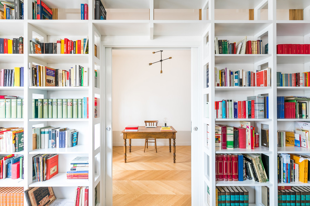 Esempio di uno studio classico con libreria, parquet chiaro, scrivania autoportante, pareti bianche e pavimento beige