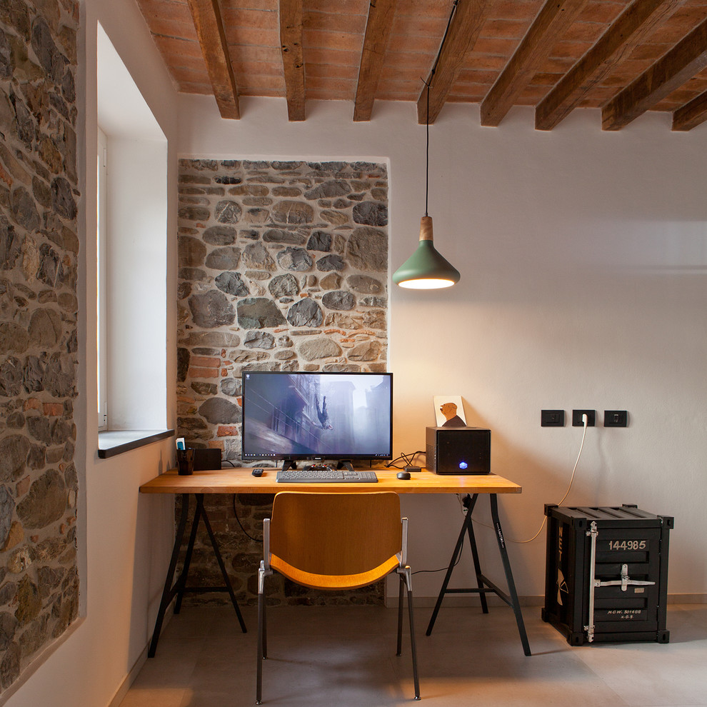 На фото: маленькое рабочее место в средиземноморском стиле с белыми стенами, серым полом и отдельно стоящим рабочим столом для на участке и в саду с