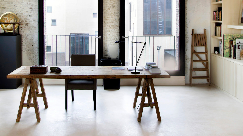 Imagen de despacho bohemio con paredes blancas, suelo de cemento, escritorio independiente y suelo blanco