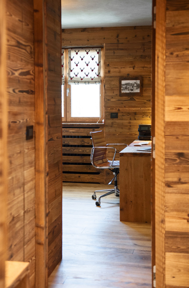 Aménagement d'un bureau montagne de taille moyenne et de type studio avec un mur multicolore, aucune cheminée, un bureau indépendant et un sol en bois brun.
