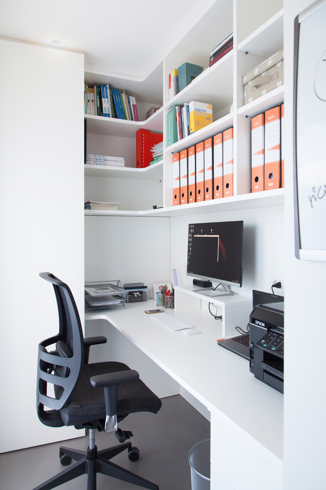 Esempio di un piccolo ufficio contemporaneo con pareti bianche, pavimento in cemento, scrivania incassata e pavimento grigio
