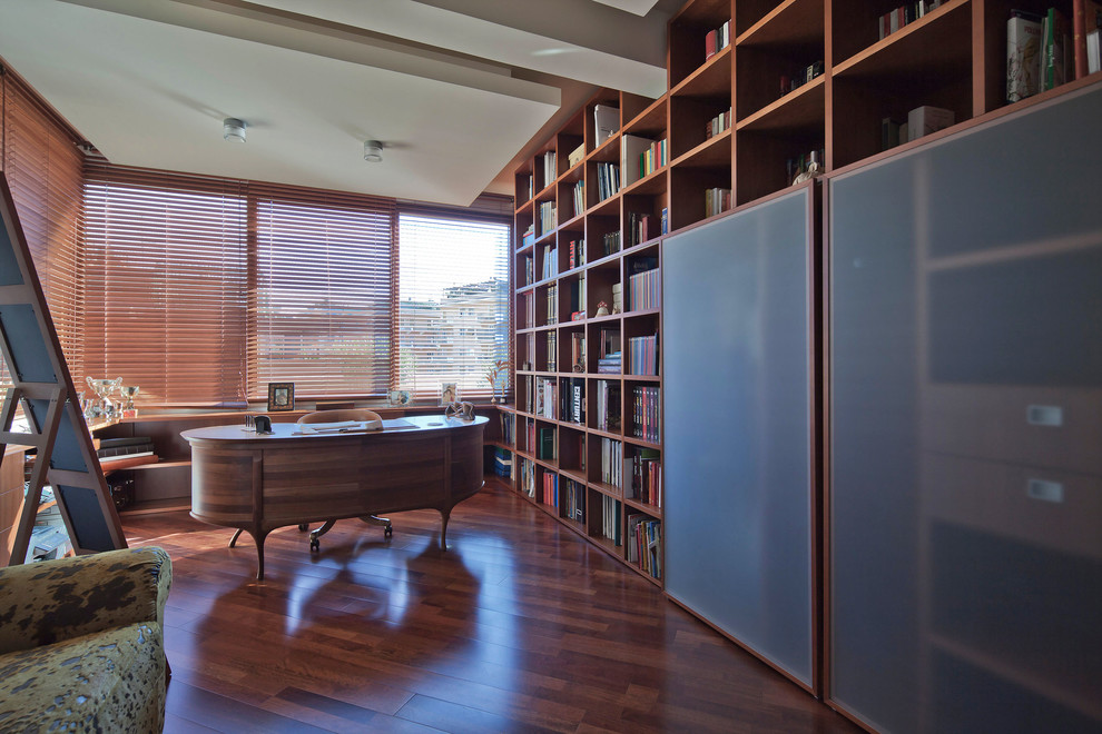Réalisation d'un très grand bureau design avec une bibliothèque ou un coin lecture, un mur blanc, parquet foncé et un bureau indépendant.