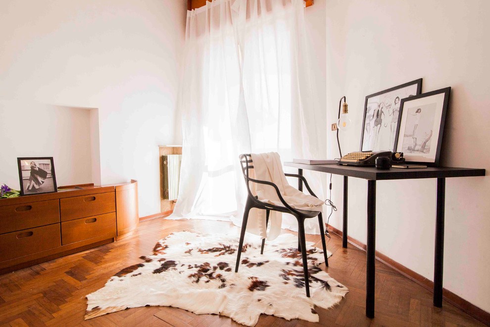 This is an example of a scandi study in Milan with white walls, medium hardwood flooring and a freestanding desk.