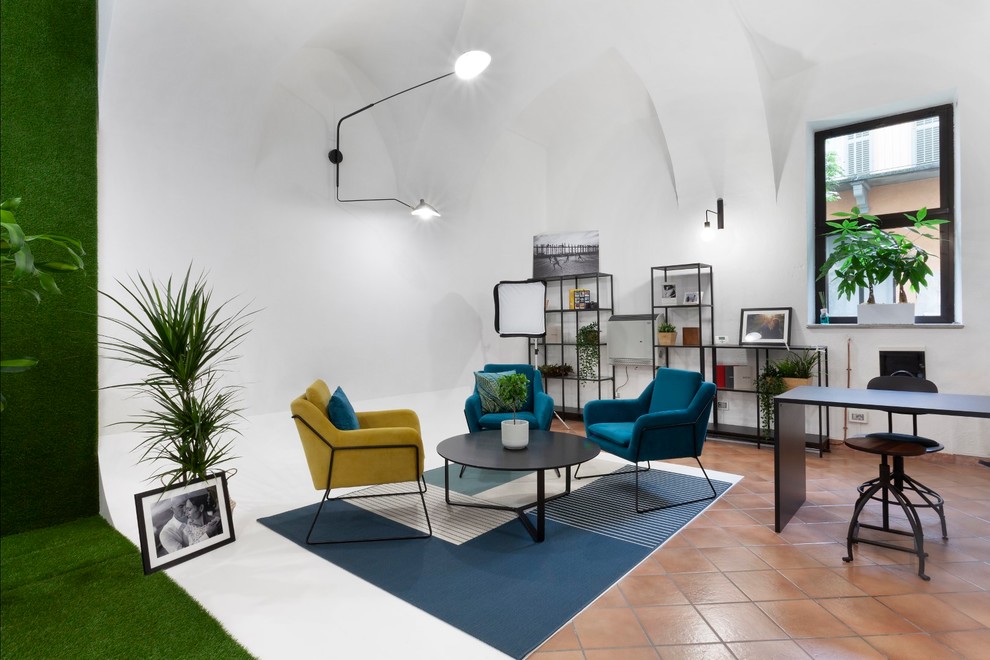 Kleines Industrial Arbeitszimmer mit Studio, weißer Wandfarbe, Terrakottaboden und freistehendem Schreibtisch in Turin