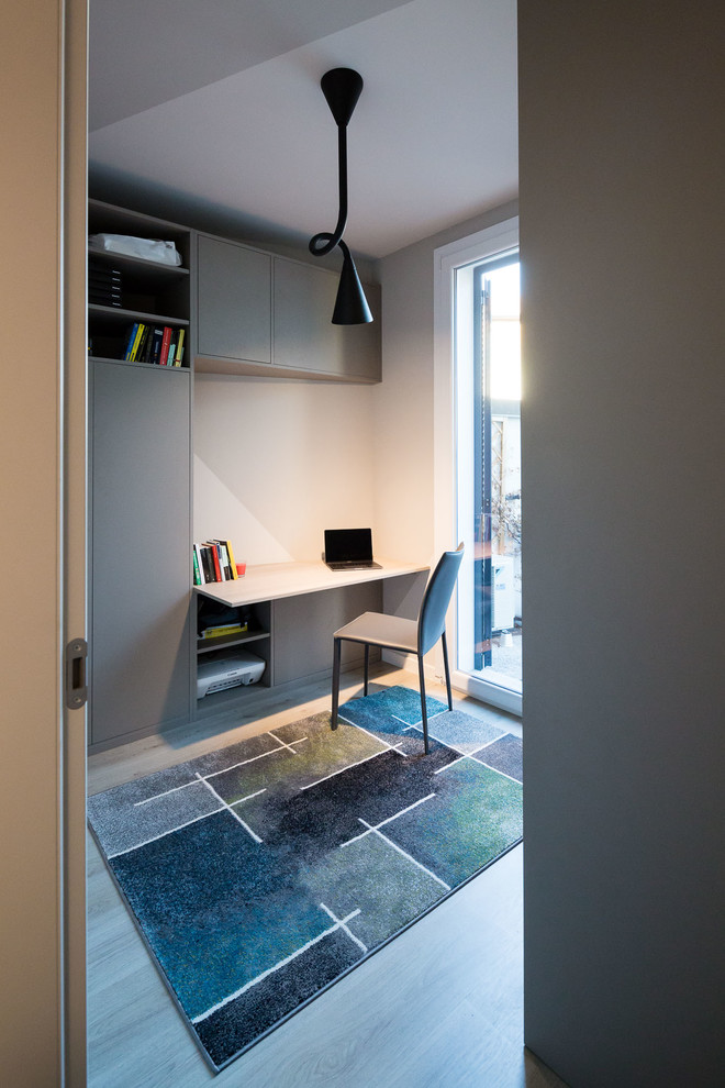 Immagine di una piccola stanza da lavoro contemporanea con pareti grigie, pavimento in legno massello medio, scrivania incassata e pavimento grigio