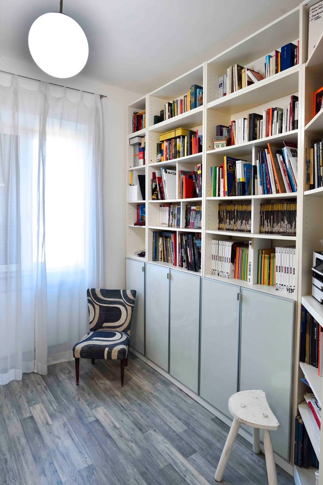 Пример оригинального дизайна: домашняя библиотека среднего размера в современном стиле с белыми стенами, полом из ламината, отдельно стоящим рабочим столом и серым полом