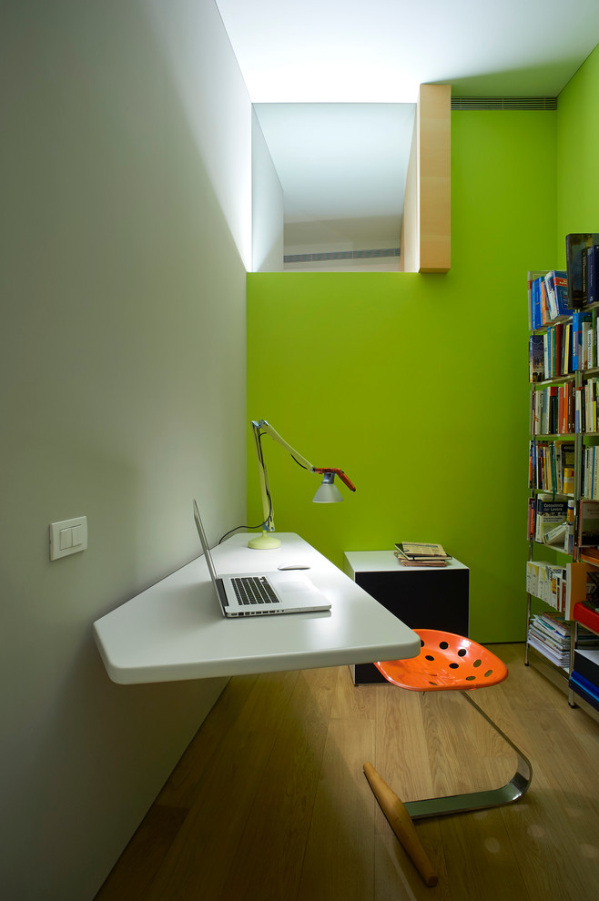 На фото: рабочее место в современном стиле с зелеными стенами, светлым паркетным полом и отдельно стоящим рабочим столом