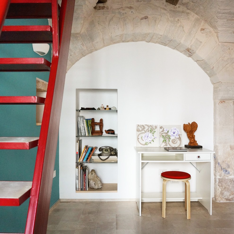 Imagen de despacho bohemio pequeño con paredes multicolor, suelo de piedra caliza y escritorio independiente