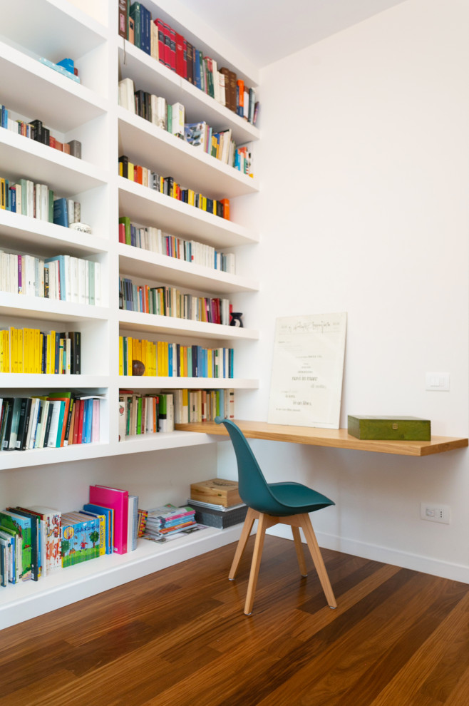 Immagine di un atelier minimalista con pareti bianche, parquet scuro, camino classico, scrivania autoportante e pavimento marrone