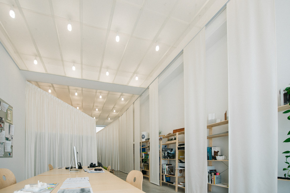 Exemple d'un petit bureau tendance avec un mur blanc, sol en béton ciré, aucune cheminée et un bureau indépendant.