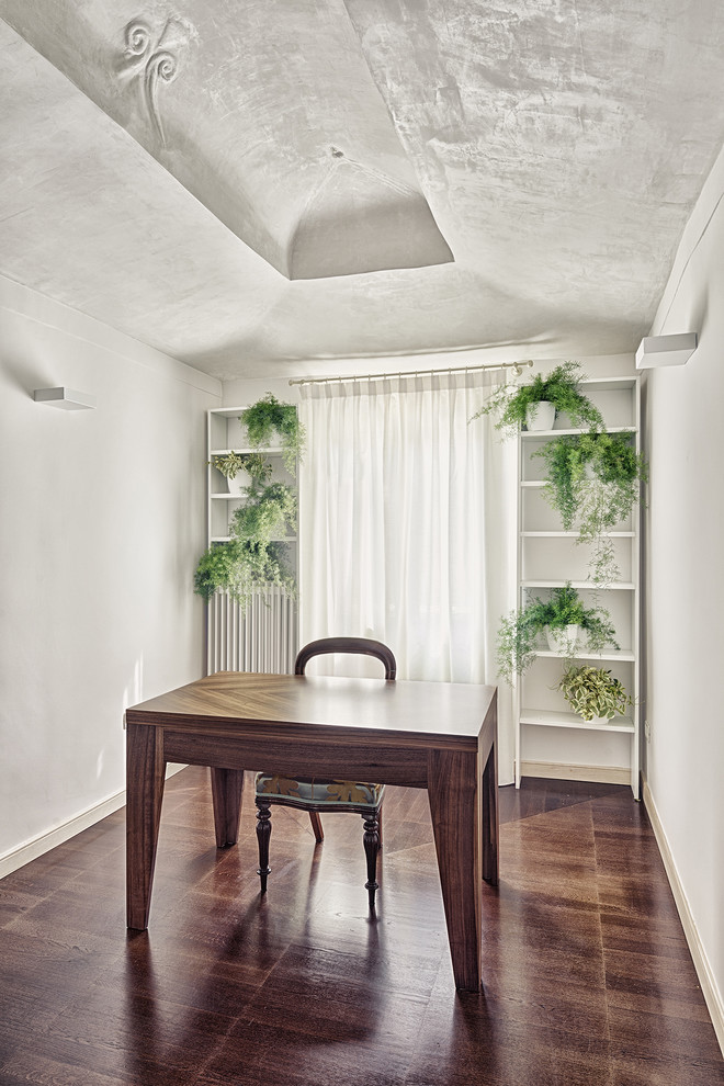 Foto de estudio moderno de tamaño medio con paredes blancas, suelo de madera oscura y escritorio independiente