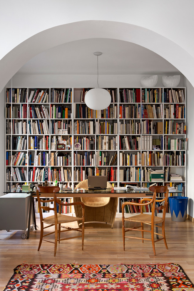 Idéer för att renovera ett mellanstort funkis hemmabibliotek, med vita väggar, ljust trägolv och ett fristående skrivbord