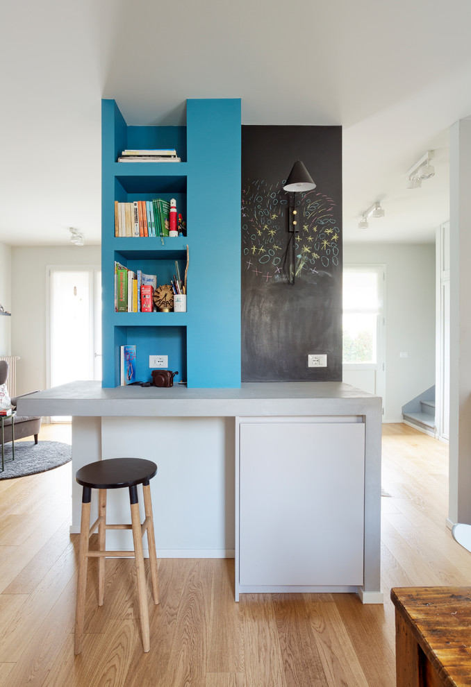 Foto di uno studio bohémian con pareti blu, pavimento in legno massello medio, scrivania incassata e pavimento marrone