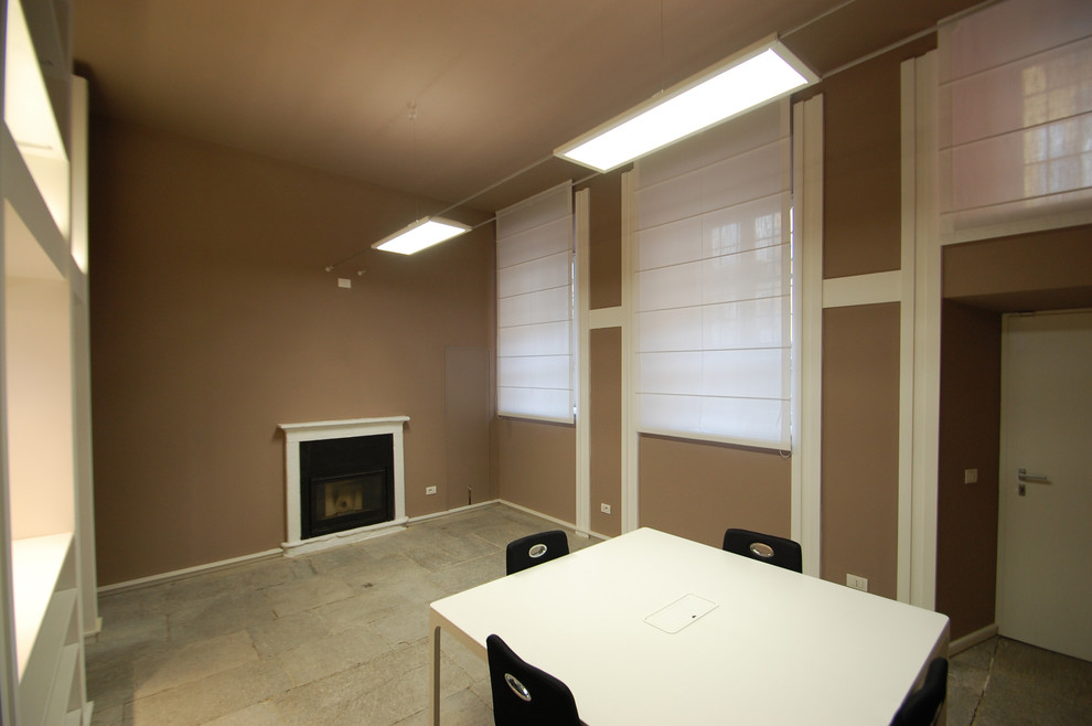 Imagen de despacho contemporáneo grande con paredes marrones, suelo de piedra caliza, todas las chimeneas, marco de chimenea de hormigón, escritorio independiente y suelo gris