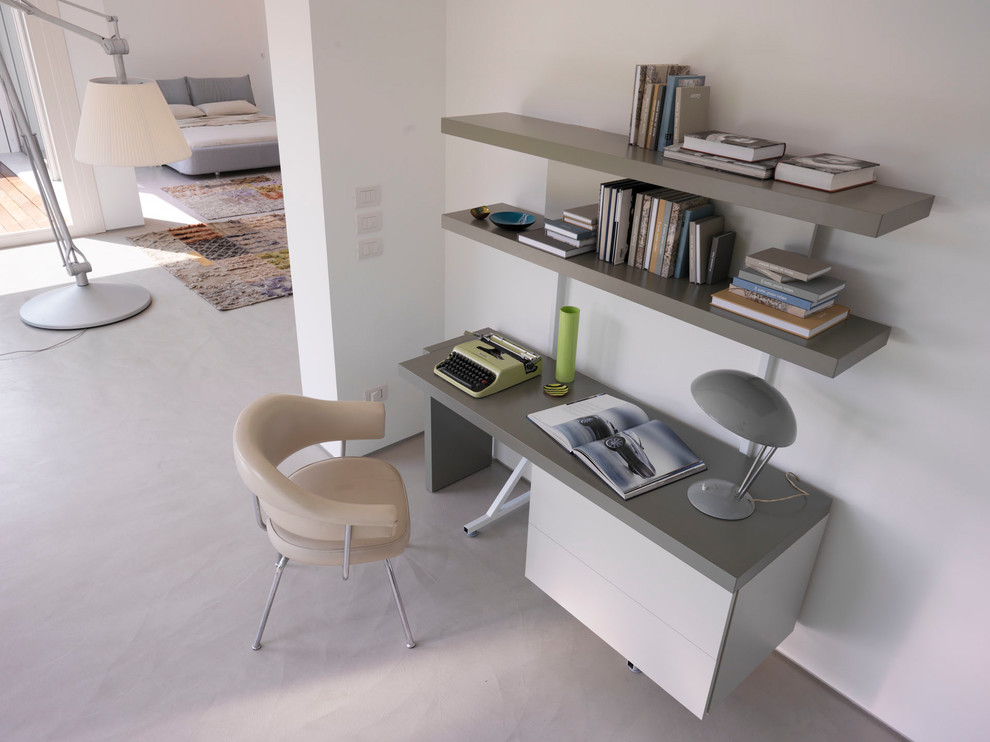Modern inredning av ett litet arbetsrum, med vita väggar och ett fristående skrivbord