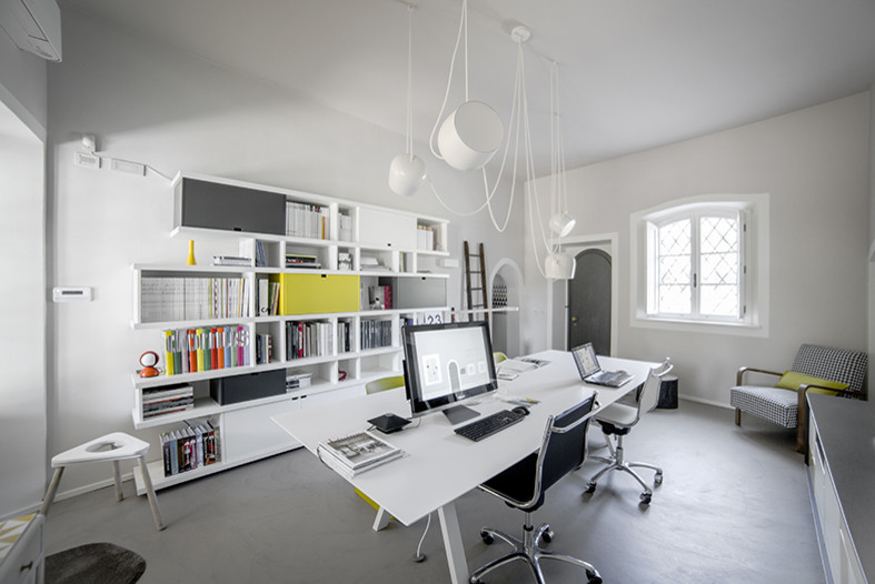 Idee per un atelier minimal di medie dimensioni con pareti grigie e pavimento in cemento