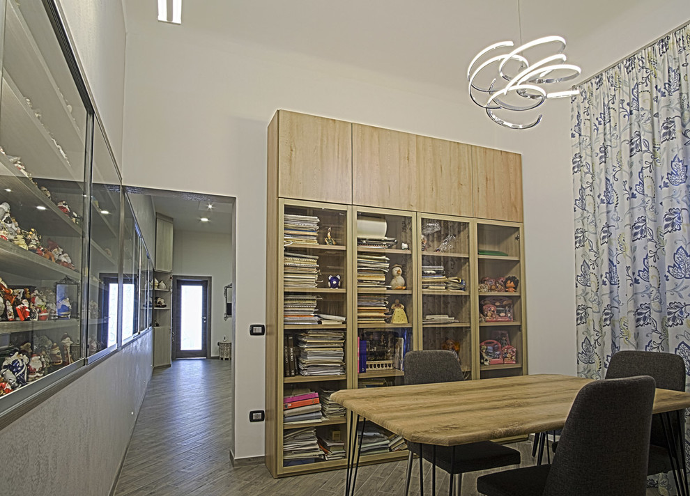 Cette photo montre un bureau moderne avec une bibliothèque ou un coin lecture, un mur gris, un sol en carrelage de porcelaine et un sol gris.