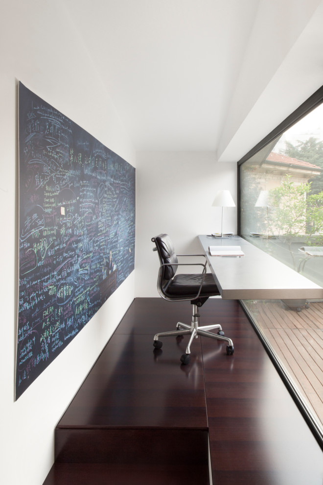 Ispirazione per un piccolo ufficio contemporaneo con pareti bianche, nessun camino, scrivania incassata e pavimento marrone
