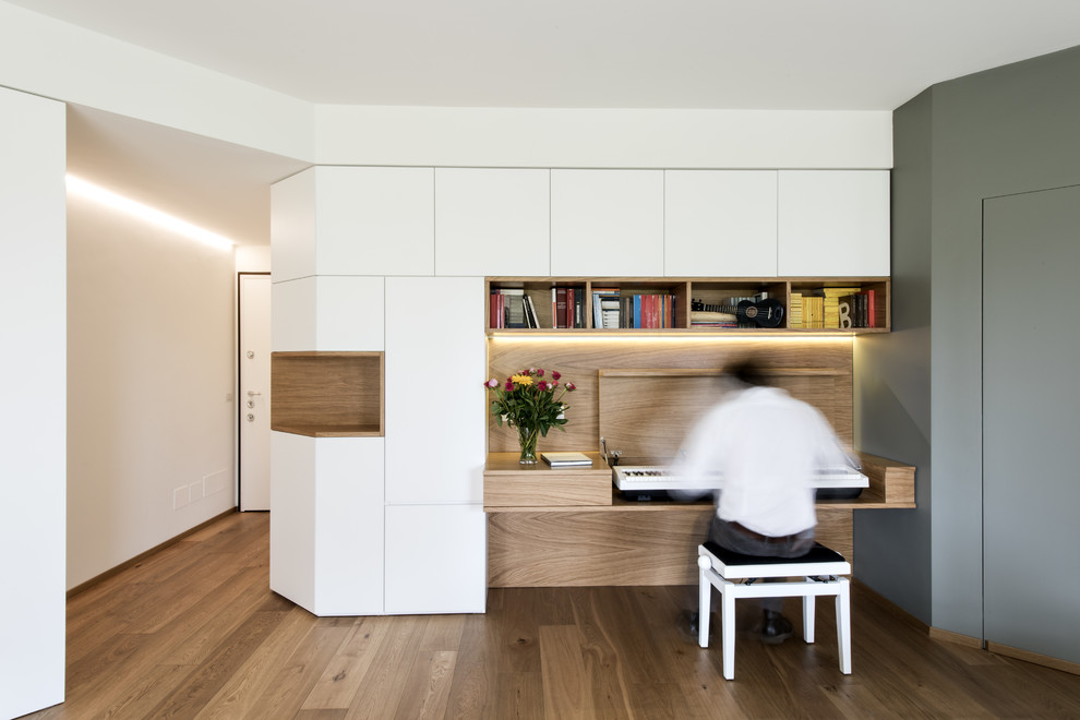 Idee per un grande studio minimalista con libreria, pareti bianche, parquet chiaro, pavimento beige e scrivania incassata
