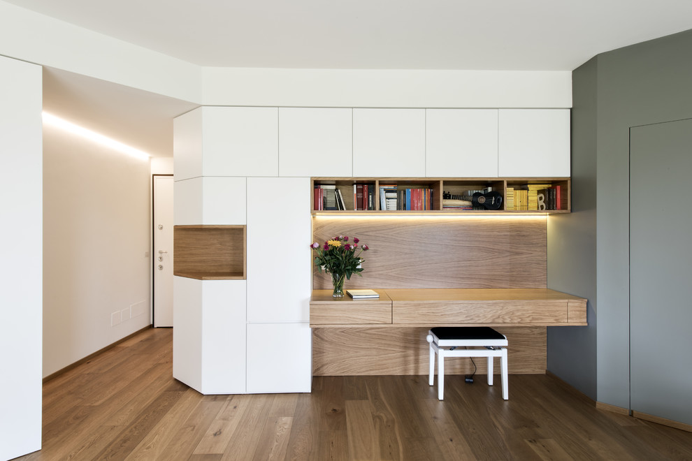 Inspiration för mellanstora moderna arbetsrum, med ett bibliotek, vita väggar, ljust trägolv, beiget golv och ett inbyggt skrivbord