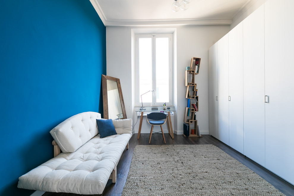 Источник вдохновения для домашнего уюта: рабочее место в современном стиле с синими стенами, отдельно стоящим рабочим столом и темным паркетным полом без камина