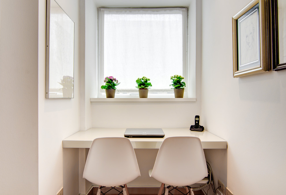 Inspiration for a small contemporary built-in desk light wood floor and beige floor home studio remodel in Milan with white walls