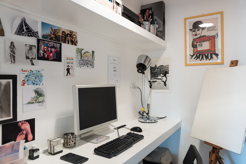 На фото: рабочее место в современном стиле с белыми стенами и встроенным рабочим столом