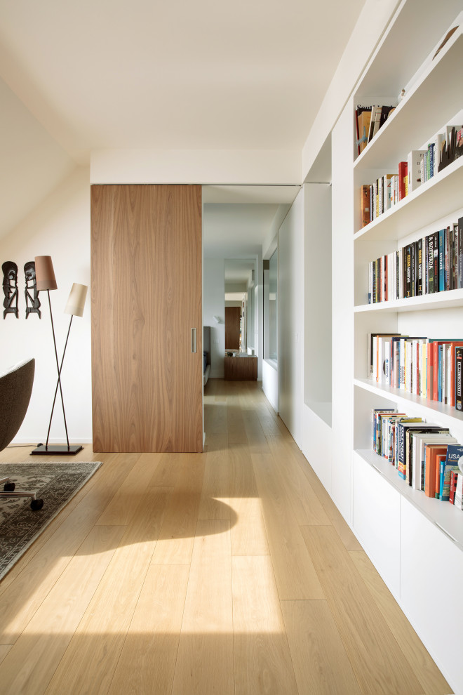Idéer för ett stort modernt hemmastudio, med vita väggar och ljust trägolv