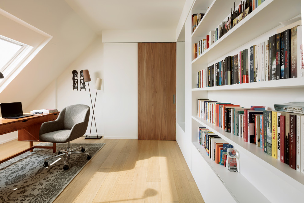Idéer för ett stort modernt hemmastudio, med vita väggar och ljust trägolv