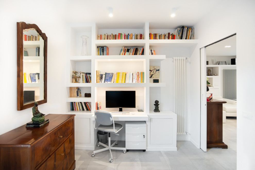 Esempio di un piccolo studio minimal con libreria e pareti bianche