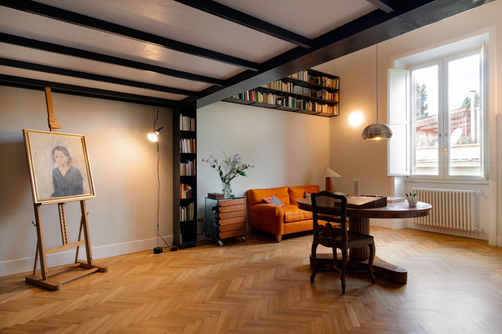 Modelo de despacho minimalista grande con biblioteca, paredes blancas, suelo de madera en tonos medios, escritorio independiente y suelo beige